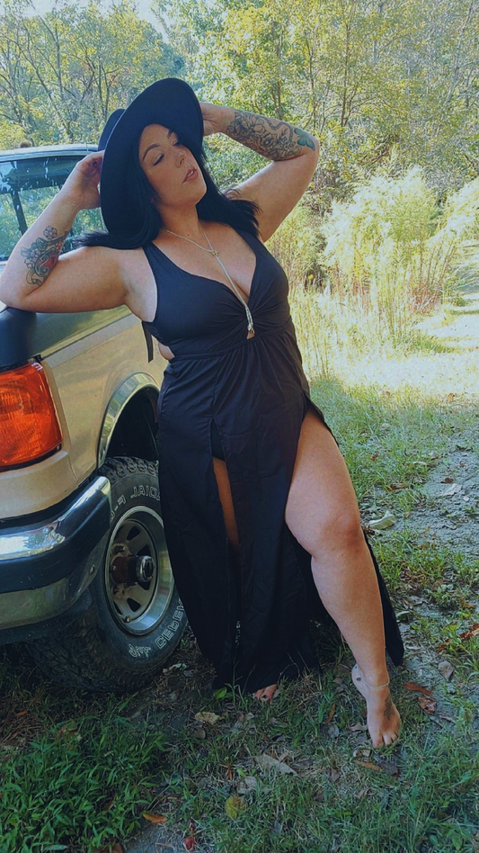 Women wearing a beach black maxie dress with 2 slits up the side.